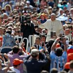 Pope Francis greets the crowd as he arrives for his weekly general audience in St. Peter's Square
