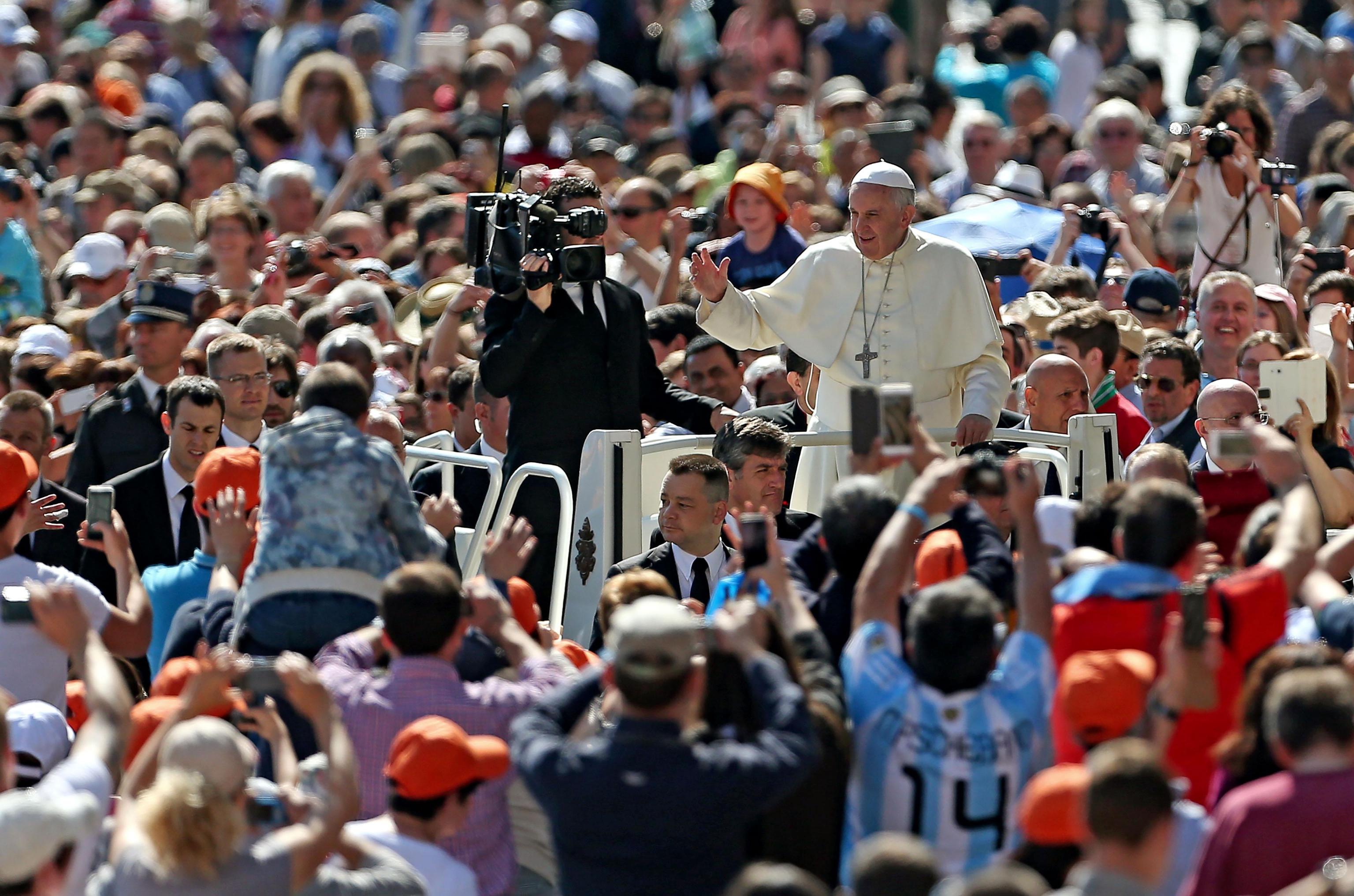 Pope Francis greets the crowd as he arrives for his weekly general audience in St. Peter's Square