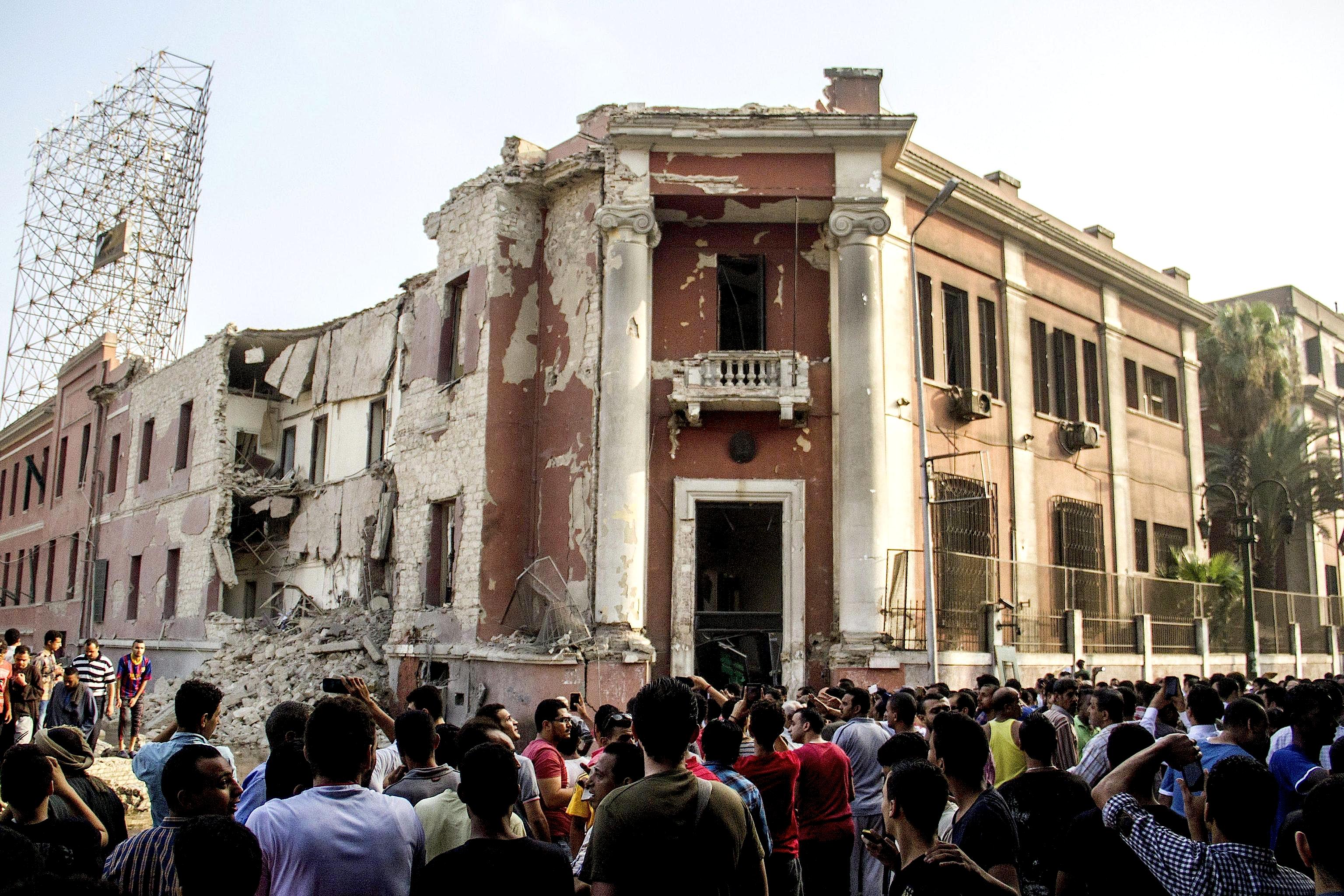 Bystanders at the site following a bomb blast at the Italian Consulate in Cairo