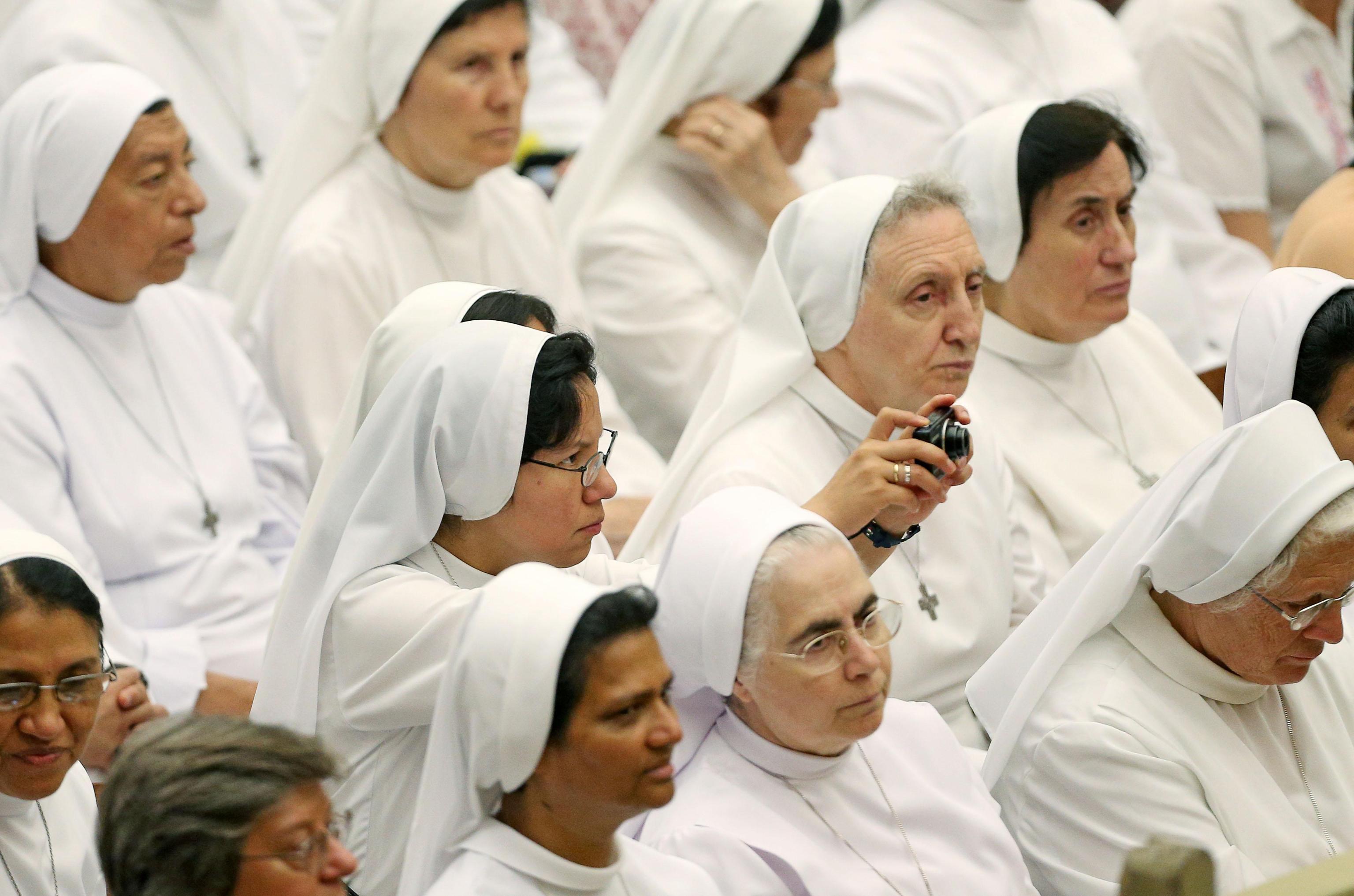A sister takes a picture during the General Audience in the Paul VI Audience Hall