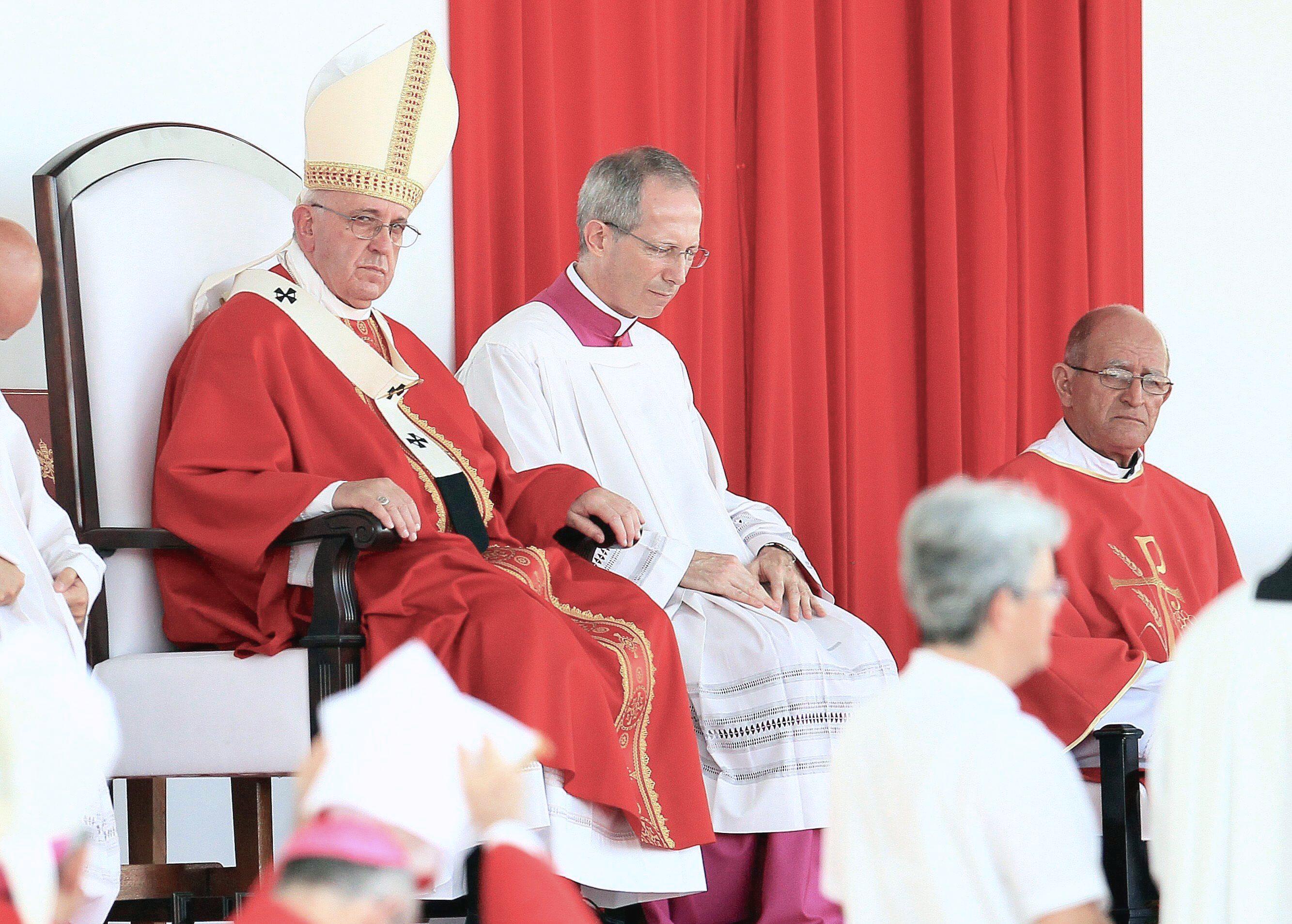 Pope Francis (L) looks on during a mass at Revolution Square in the city of Holguin