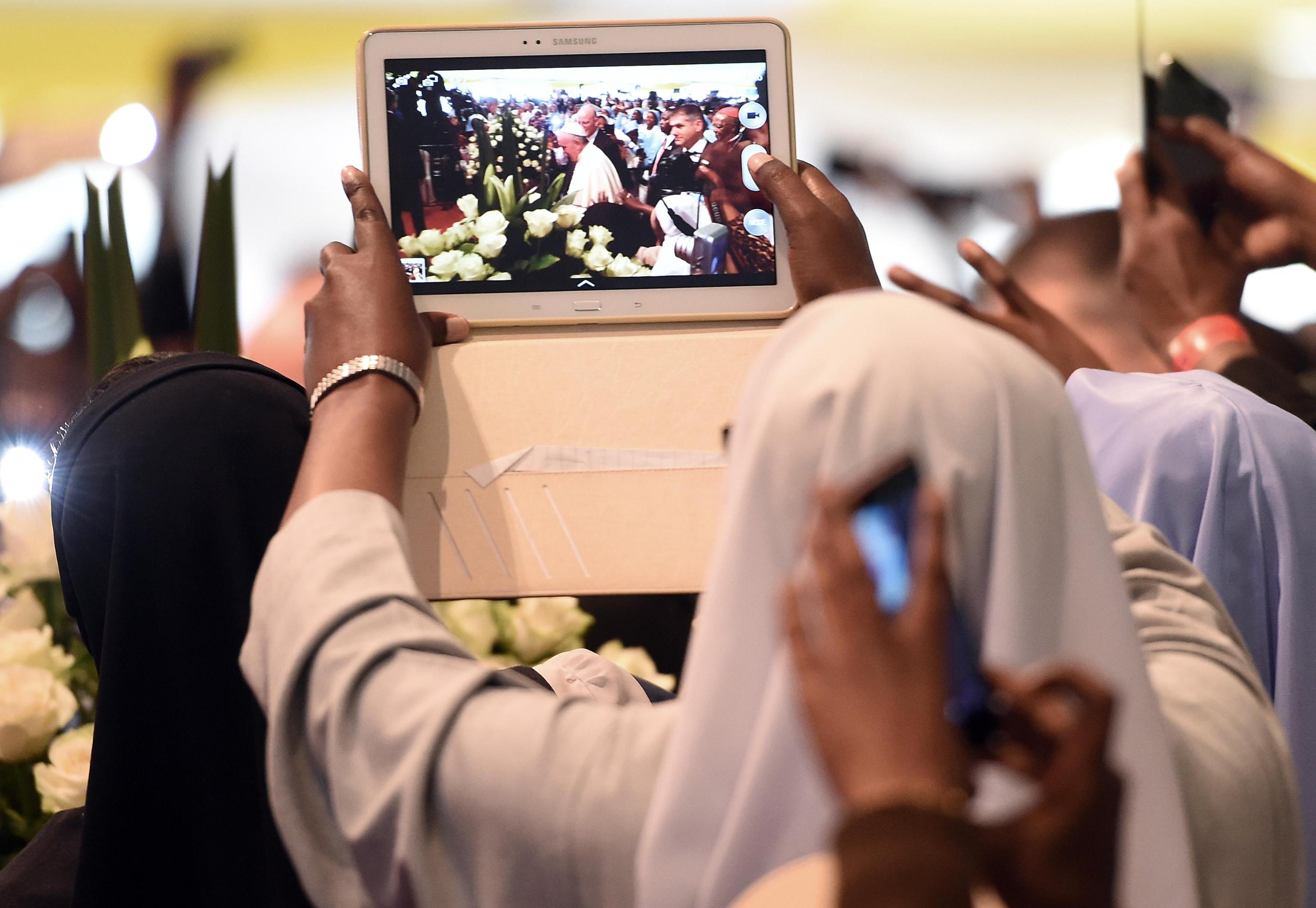 A nun records on a tablet the arrival of Pope Francis at the St. Mary's school to attend a meeting of clergy and religious in Nairobi