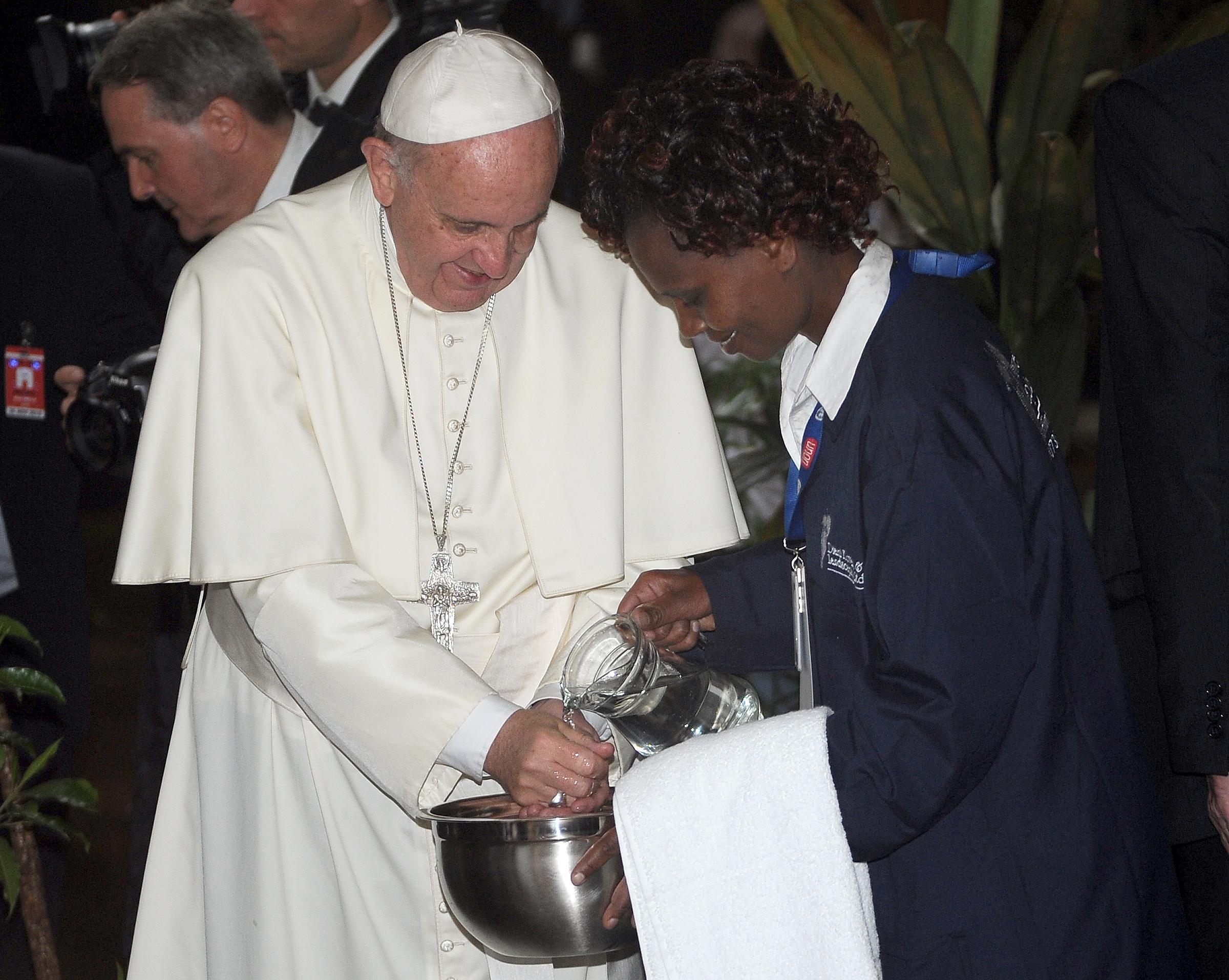 Pope Francis washes his hands after planting a tree during a visit to the United Nations Office in Nairobi