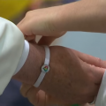 Un enfant de la "Fabrique de la paix" passe un bracelet de l'asosciation au poignet du pape François, capture CTV