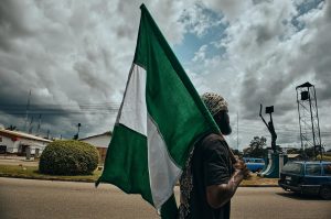 Un homme avec un drapeau nigérian à Port Harcourt, Nigeria © Emmanuel Ikwuegbu
