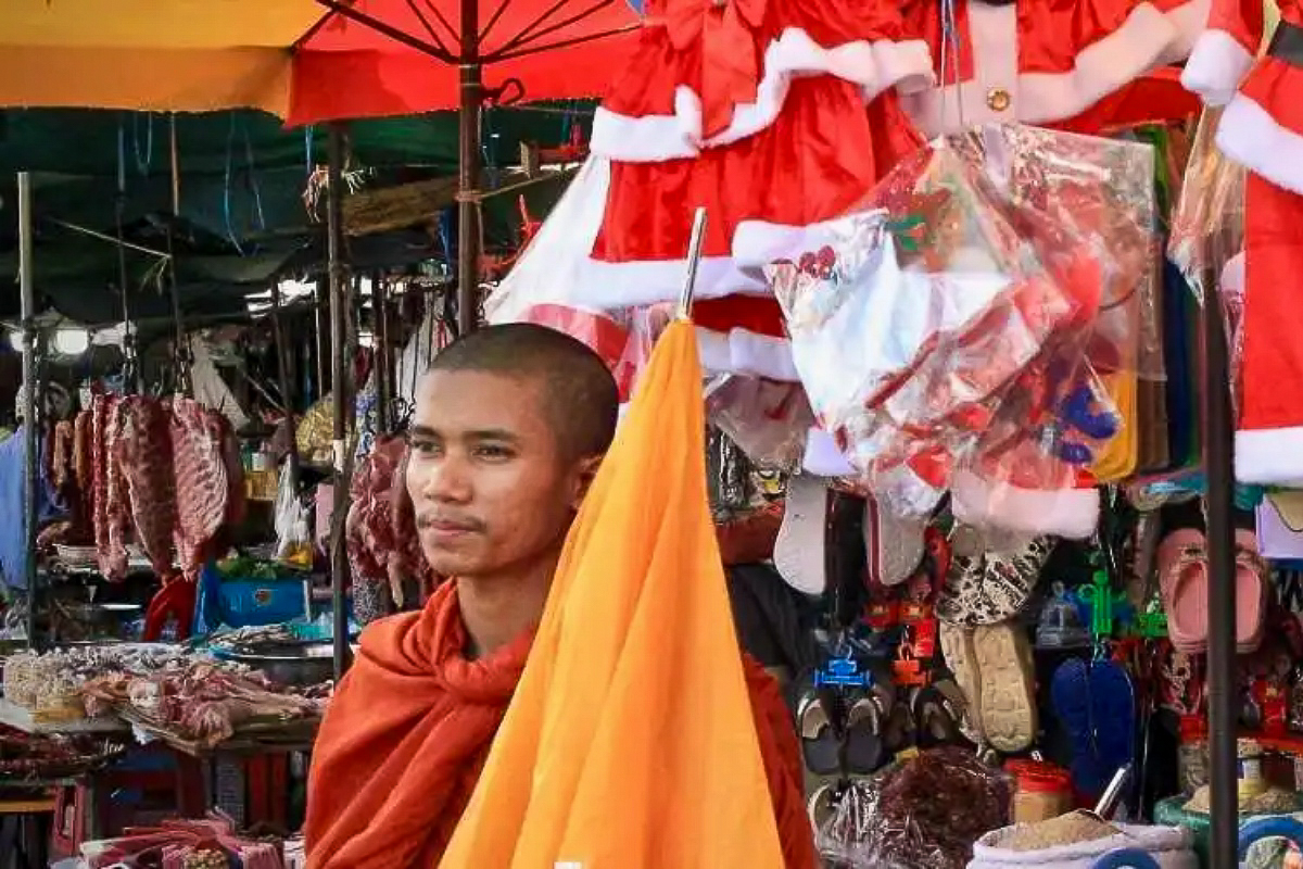 Un monje budista delante de un puesto en Navidad en el mercado de Kandal, Phnom Penh. © Luke Hunt / Ucanews