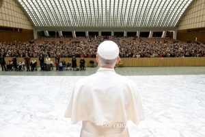 Chers frères et sœurs, merci pour votre accueil chaleureux et surtout merci d’être venus à ce rendez-vous de Noël. C’est le premier pour moi, et c’est la première fois que je vous rencontre tous ensemble, avec beaucoup de vos proches, et cela me fait très plaisir! Aujourd’hui, nous ne devons pas parler de travail, mais je veux profiter de cette occasion pour remercier chacun d’entre vous pour le travail que vous accomplissez. J’apprends à connaître le Vatican comme une grande mosaïque de bureaux et de services, et petit à petit, avec l’aide de Dieu, je pense que je pourrai aussi vous rencontrer en visitant les différents lieux de travail. Mais aujourd’hui, je suis content de ce moment familial presque à la veille de Noël. Nous le vivons devant la crèche, qui est également présente ici, dans cette scène de la Nativité offerte par le Costa Rica. Dans la crèche, l’imagination populaire a souvent inséré de nombreux personnages tirés de la vie quotidienne, qui peuplent l’espace autour de la grotte. Ainsi, outre les incontournables bergers, protagonistes de l'événement selon l’Evangile, on trouve des figurines représentant différents métiers: le forgeron, le tavernier, l'aubergiste, la lavandière, le rémouleur, etc. Il s’agit bien sûr de métiers d’autrefois: certains ont disparu ou ont été totalement transformés. Cependant, ils conservent leur signification au sein de la crèche. Ils nous rappellent que toutes nos activités, nos occupations quotidiennes, prennent tout leur sens dans le dessein de Dieu, qui a son centre en Jésus-Christ. C’est comme si l’Enfant Jésus, depuis la mangeoire où il est couché, bénissait tout et tout le monde. Sa présence douce et humble répand partout la tendresse de Dieu. Tandis que Marie et Joseph adorent l’Enfant et que les bergers s’approchent, émerveillés, les autres personnages vaquent à leurs occupations quotidiennes. Ils semblent détachés de l’événement central, mais ce n’est pas le cas: en réalité, chacun y participe tel qu’il est, en restant à sa place et en faisant ce qu’il doit faire, son métier. J’aime penser qu’il peut en être de même pour nous, dans nos journées de travail: chacun de nous accomplit sa tâche et nous louons Dieu précisément en la faisant bien, avec application. Parfois, nous sommes tellement pris par nos occupations que nous ne pensons pas au Seigneur ou à l’Eglise, mais le fait même de travailler avec dévouement, en essayant de faire de son mieux, et aussi — pour vous, laïcs — avec amour pour votre famille, pour vos enfants, cela rend gloire au Seigneur. Très chers amis, apprenons du Noël de Jésus le style de la simplicité, de l’humilité, et faisons en sorte, tous ensemble, que ce soit toujours plus le style de l’Eglise, dans toute son expression. Je vous prie de transmettre mes salutations à vos proches à la maison; dites surtout aux personnes âgées ou malades que le Pape prie pour elles. Je vous souhaite un saint Noël, dans la joie et la sérénité que Jésus nous donne. Merci! __________________________ L'Osservatore Romano Copyright © Dicastère pour la Communication - Libreria Editrice Vaticana