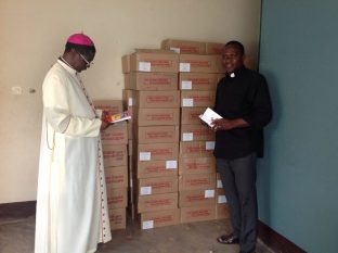 Mgr Andrew Nkea Fuanya et le père Samuel Tabeson Tanyi (directeur de l’équipe diocésaine de formation pastorale) avec les exemplaires reçus de la Bible pour enfants « Dieu parle à ses enfants » et du « Via Crucis ».
